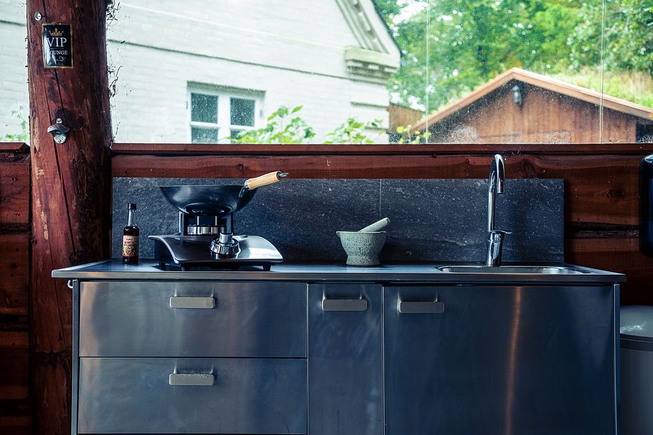 Gezellige buitenkeuken met houten eethoek.